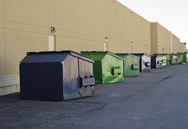 a compact construction dumpster being emptied by a waste disposal truck in Cascade